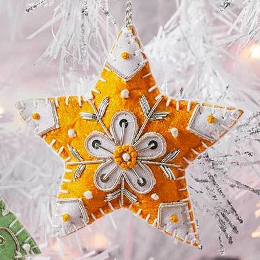 Decorative fair trade Christmas ornaments on a white tree with lights